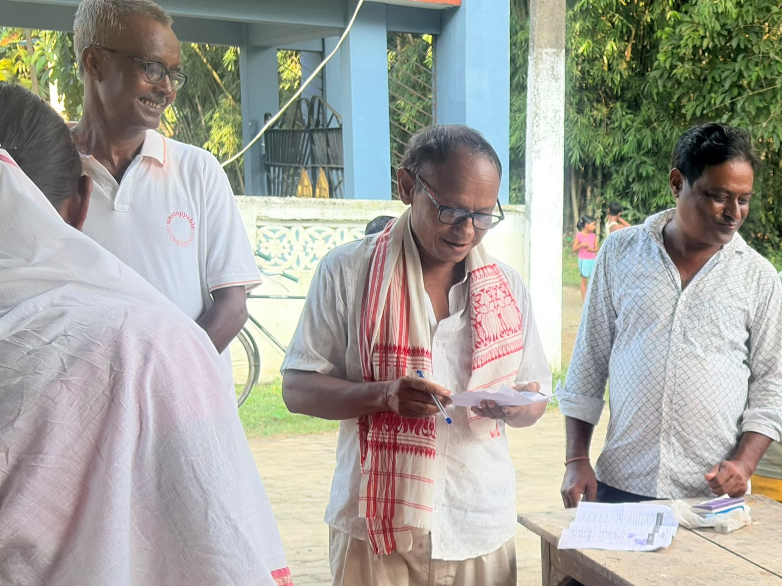 Mr. Bulu Dutta standing outside his flood-affected home, which he opened to shelter more than ten displaced families
