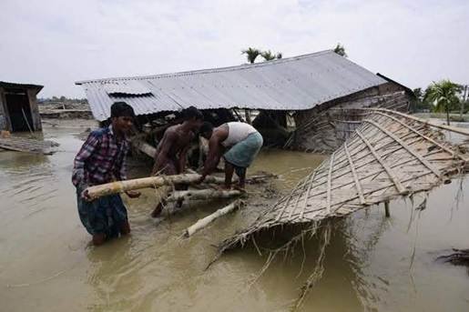 Collapsed and damaged homes in Assam — residents salvage materials from the wreckage