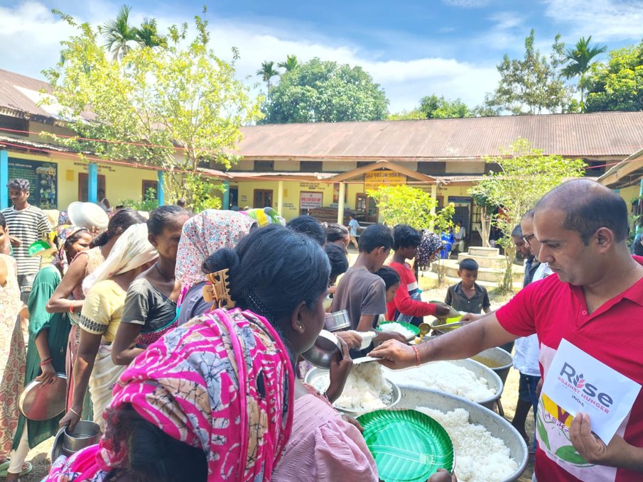 Rise Against Hunger India team serving freshly cooked meals to a queue of flood-affected families