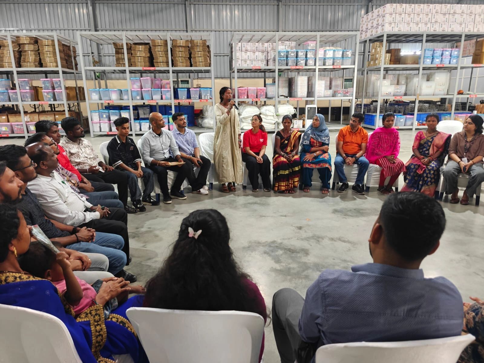 A member of the Amakund Company sharing her experience, standing and addressing the entire circle of RAHI staff and fellow Bonda women at the Bengaluru warehouse