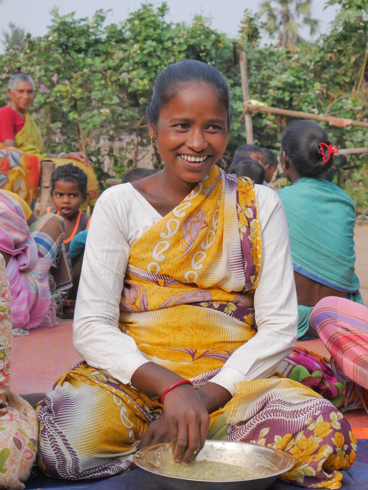 A pregnant woman smiling while having her meal at a Rise Against Hunger India Community Kitchen Centre