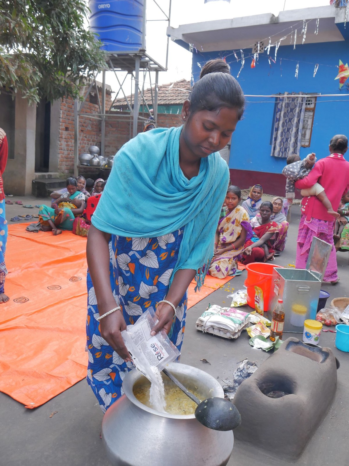 Mothers cook meals by rotation, adding local vegetables from their kitchen gardens at a RAHI Community Kitchen Centre